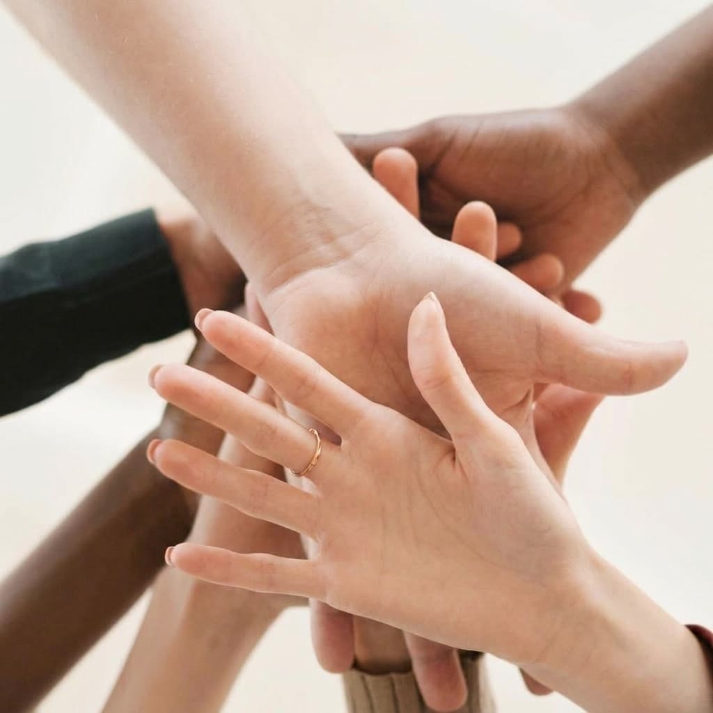 Diverse hands joined together representing community support and integration
